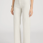 side view of woman in stripe pants and white background 