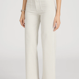 side view of woman in stripe pants and white background 