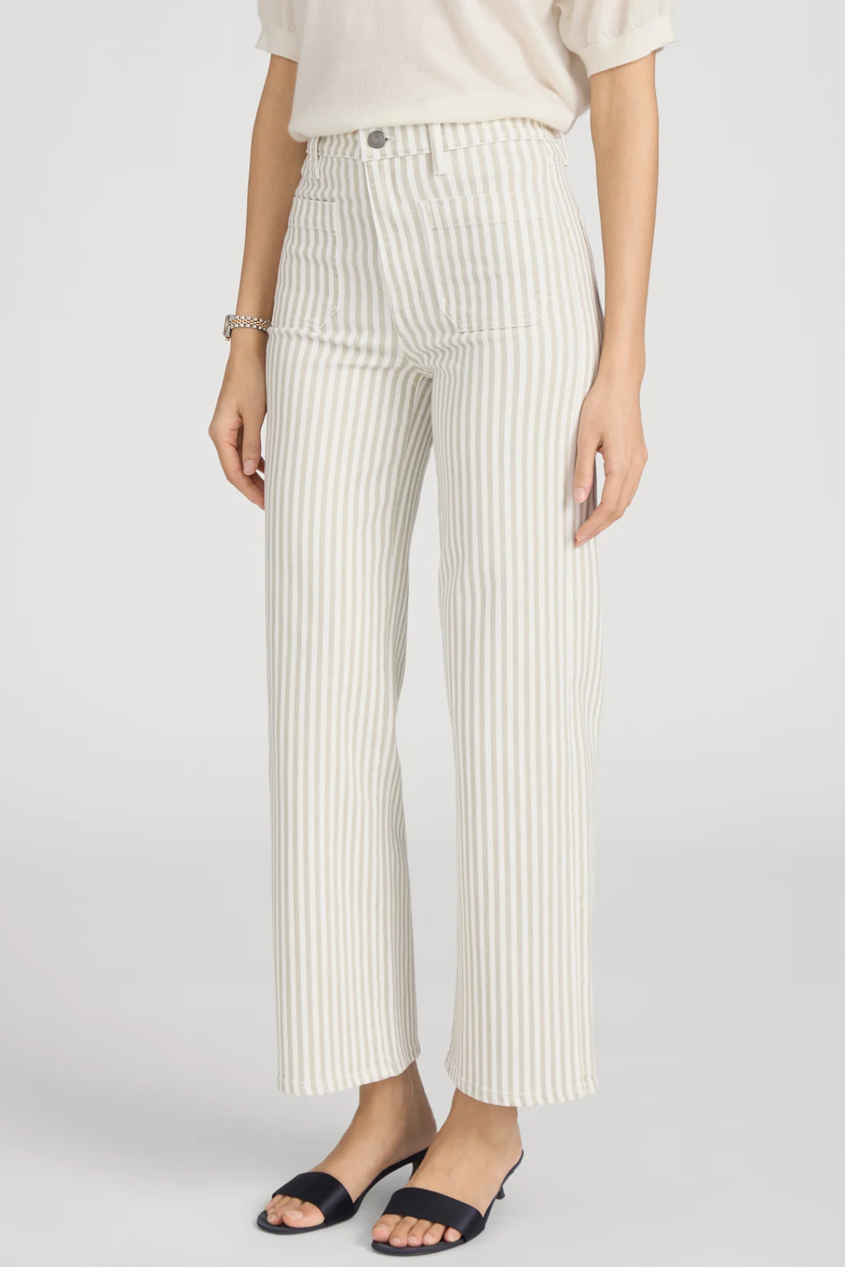 side view of woman in stripe pants and white background 