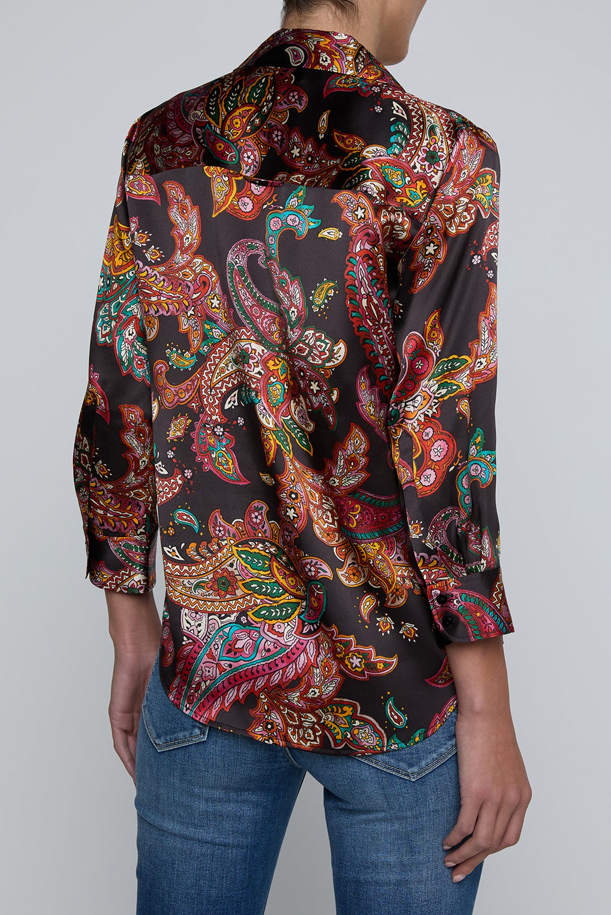 Person wearing l'agence  patterned shirt and jeans on a gray background