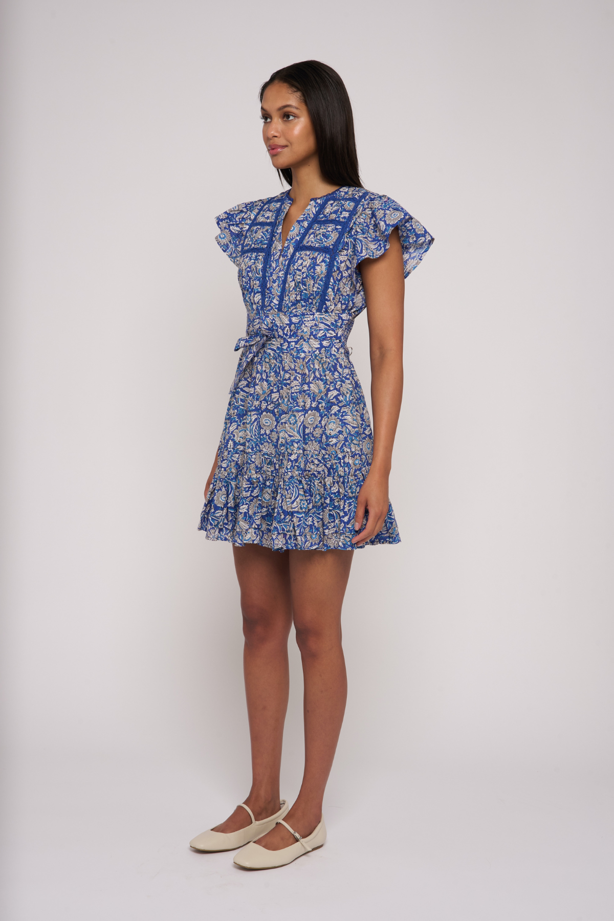 Model wearing a blue printed mini dress with short sleeves and a fitted waist.