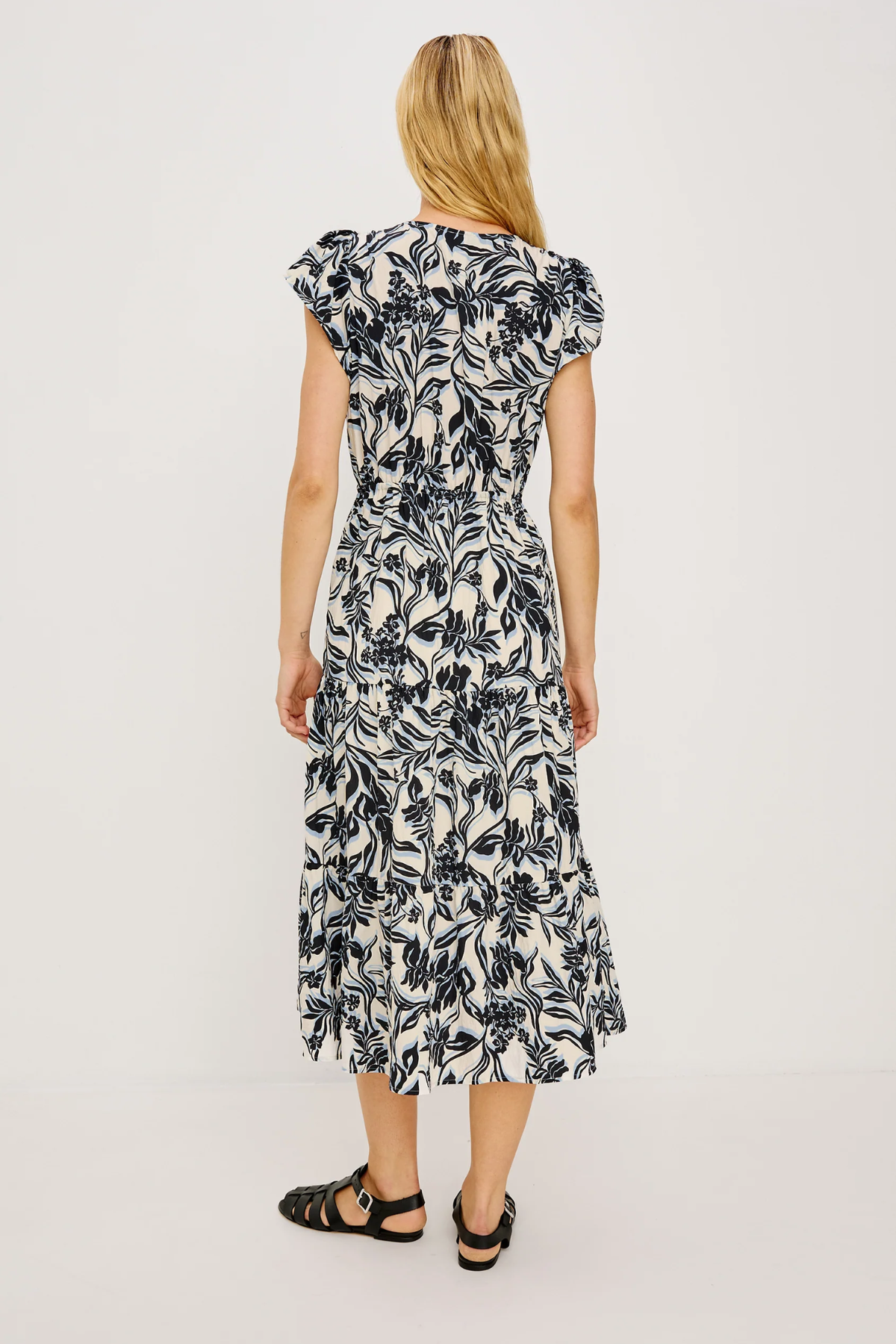 Woman wearing a black and white floral dress on a white background