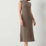 A woman modeling a sleeveless, ribbed knit midi dress in a taupe-brown color, paired with black slide sandals, against a plain light gray studio background.