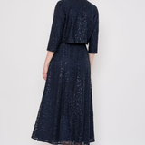 Model wearing a knee-length lace skirt with sequin detailing and a flattering fitted silhouette.