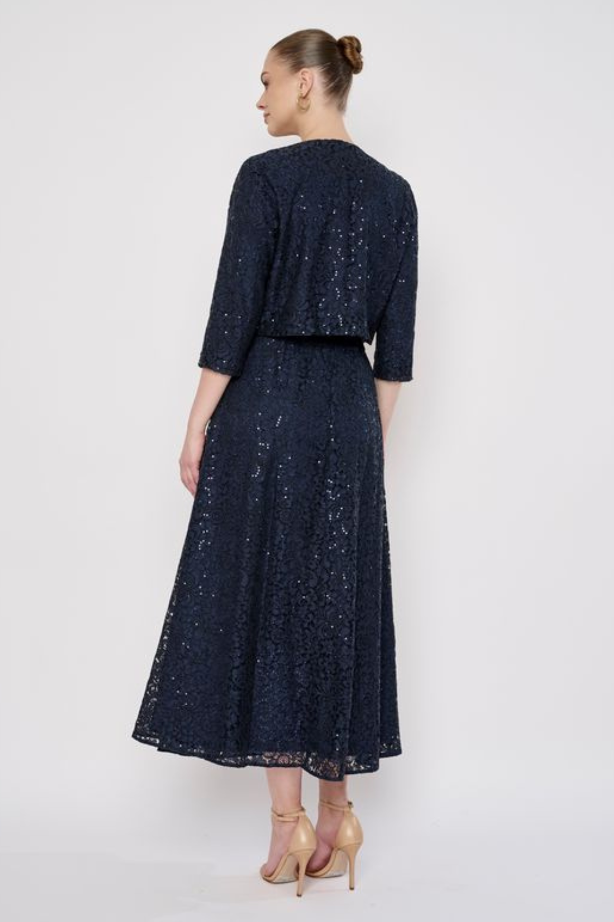 Model wearing a knee-length lace skirt with sequin detailing and a flattering fitted silhouette.
