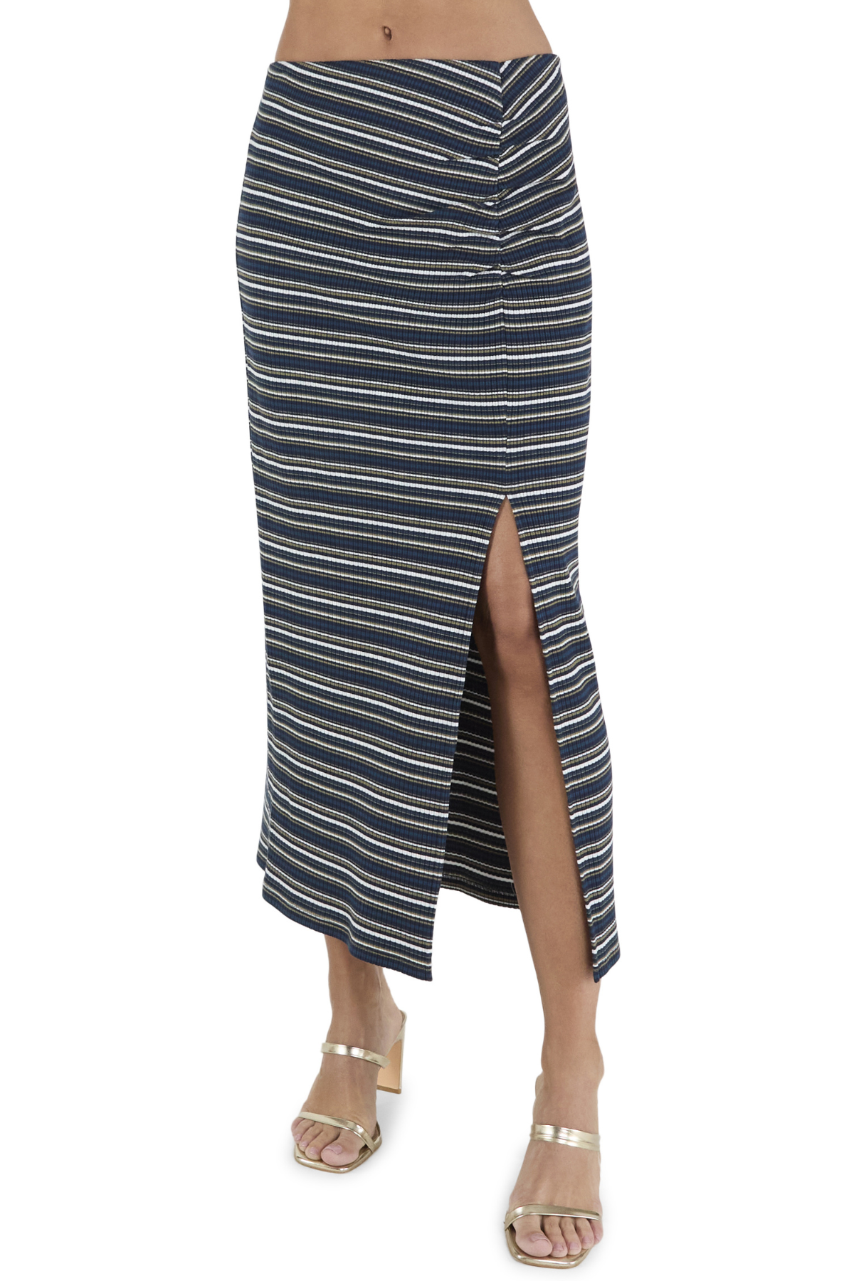 A navy blue midi skirt with thin cream and white horizontal stripes, featuring a front button closure and a high side slit, shown on a model wearing metallic sandals against a white background.
