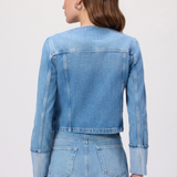 Woman wearing a denim jacket and skirt set on a white background