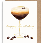 A square greeting card with a white front featuring a watercolor-style coffee cocktail, gold 'happy birthday' script, and scattered coffee beans, shown with a brown kraft envelope behind it on a white background.