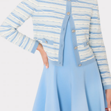 Woman wearing a blue and white striped cardigan over a light blue dress on a white background
