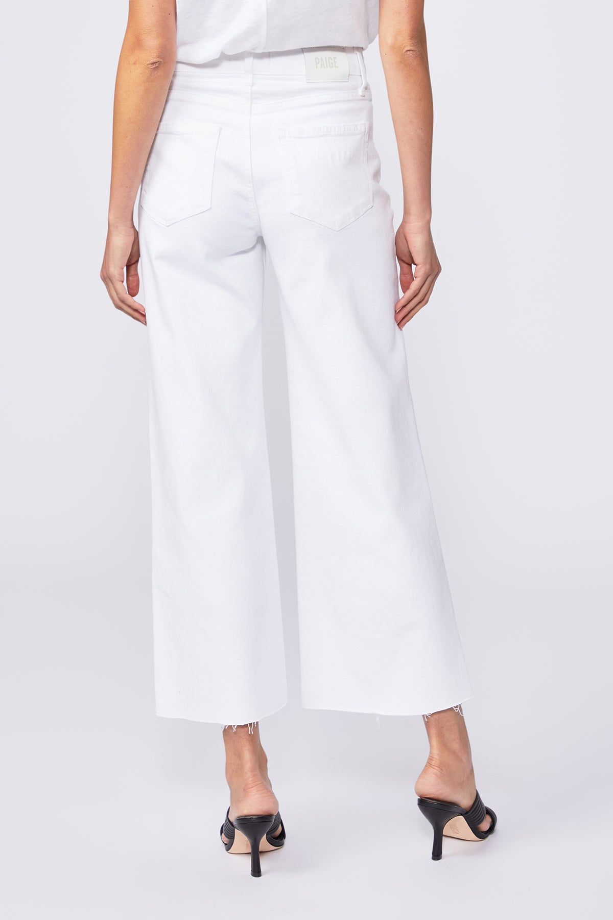 Person wearing white wide-leg pants on a plain background