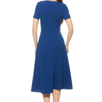back of woman in blue midi dress on white background 