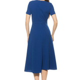 back of woman in blue midi dress on white background 