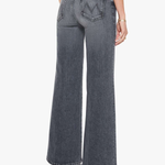A model shown from the back wearing a pair of wide-leg, high-waisted gray denim jeans with a distinctive 'W' logo on the back pocket, paired with a black top and black heels against a plain white background.