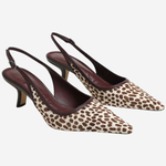 A pair of pointed-toe slingback pumps featuring a brown and beige animal print pattern with dark brown straps and heels, displayed against a light gray background.