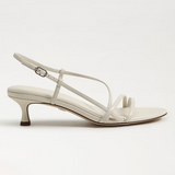 White sandal with thin straps on a light gray background