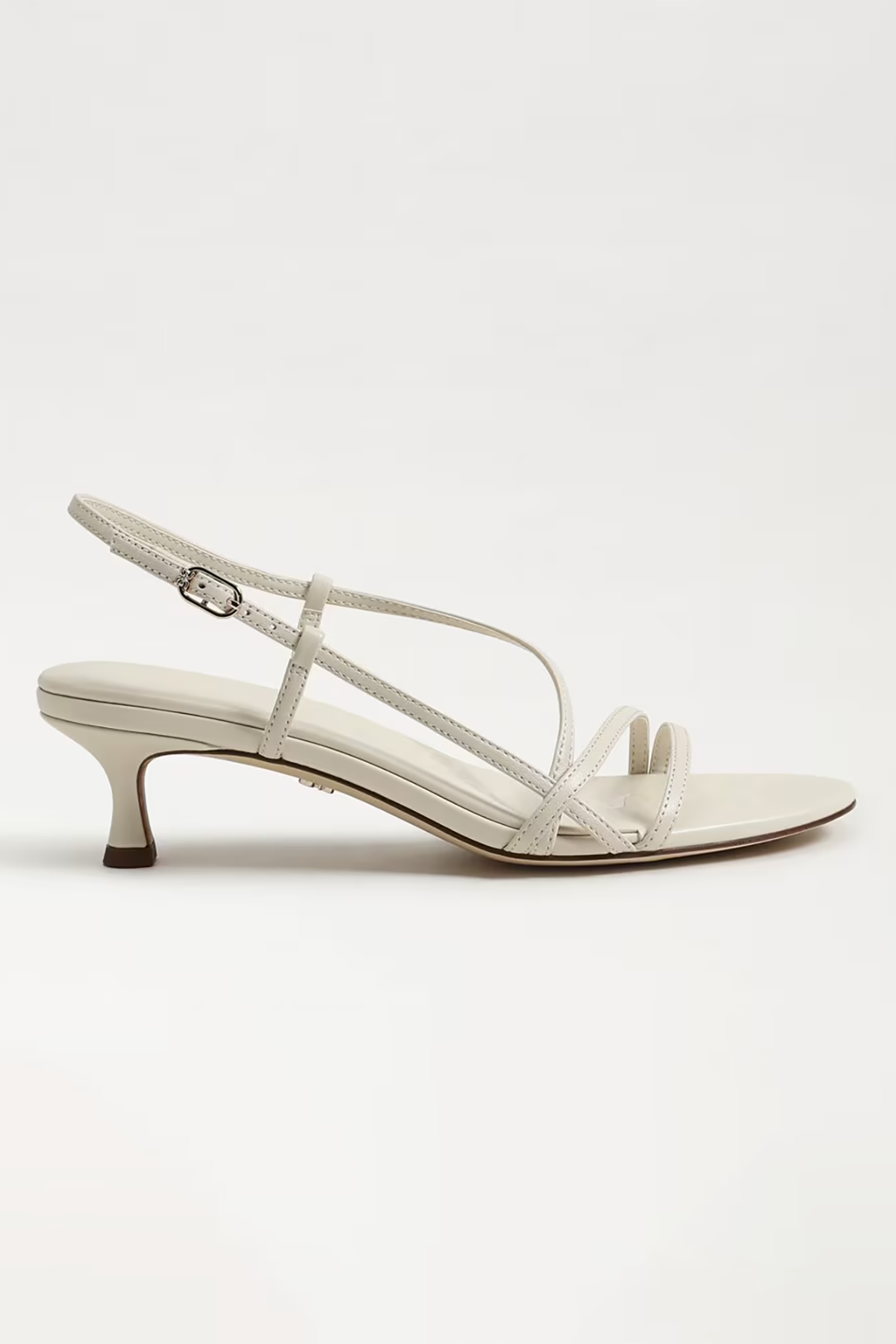White sandal with thin straps on a light gray background