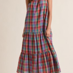 Multicolored plaid dress worn by a model on a beige background