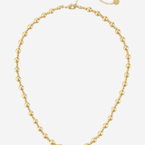 A gold beaded necklace with a delicate chain extender and a small round tag, displayed on a clean white background.