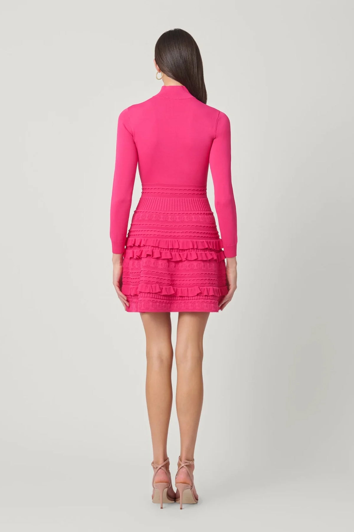 Vibrant pink dress with a sleek, structured silhouette, styled for a festive occasion