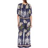 Woman wearing a navy floral jumpsuit on a white background