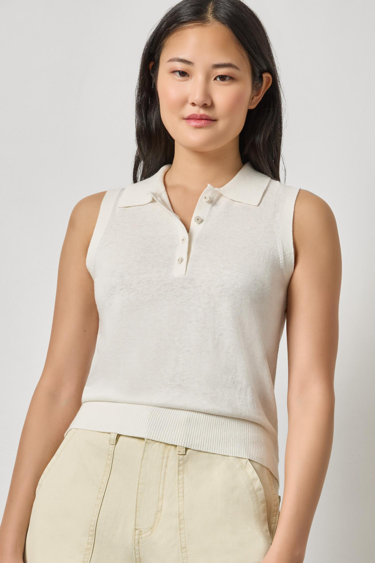 woman in white sleeveless top with collar 