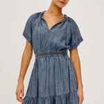 Woman wearing a denim dress against a plain background
