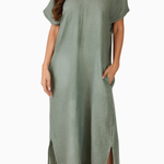 Woman wearing a green dress with a plain background