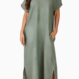 Woman wearing a green dress with a plain background