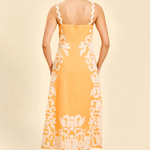 back of woman in orange embroidered midi dress