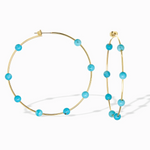 Gold hoop earrings with turquoise beads on a white background