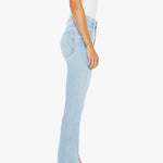 Person wearing light blue jeans and a white top on a white background