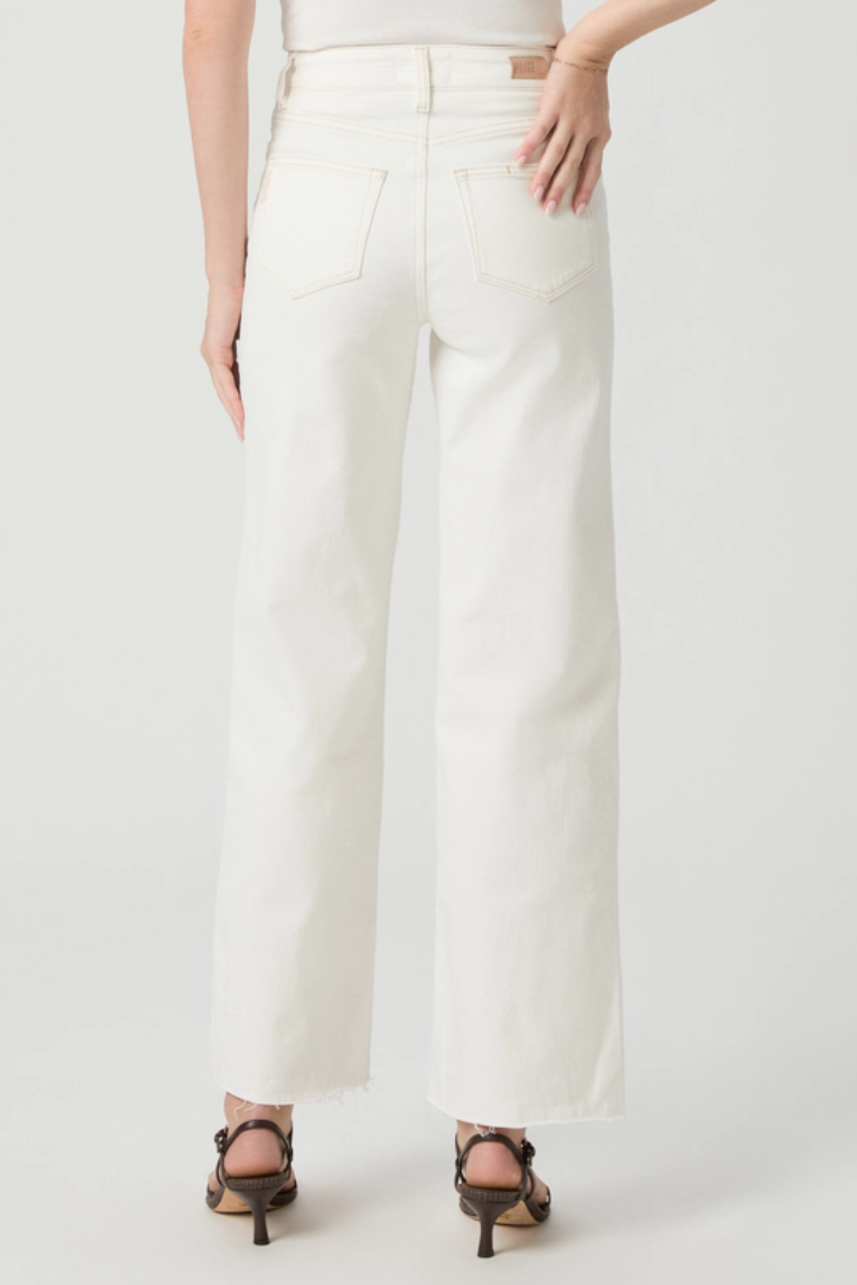 Person wearing white pants on a plain background