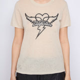 Person wearing a beige t-shirt with a black graphic design on a white background