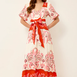 Woman wearing a floral dress with a red belt on a white background