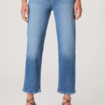 Person wearing blue jeans on a plain background