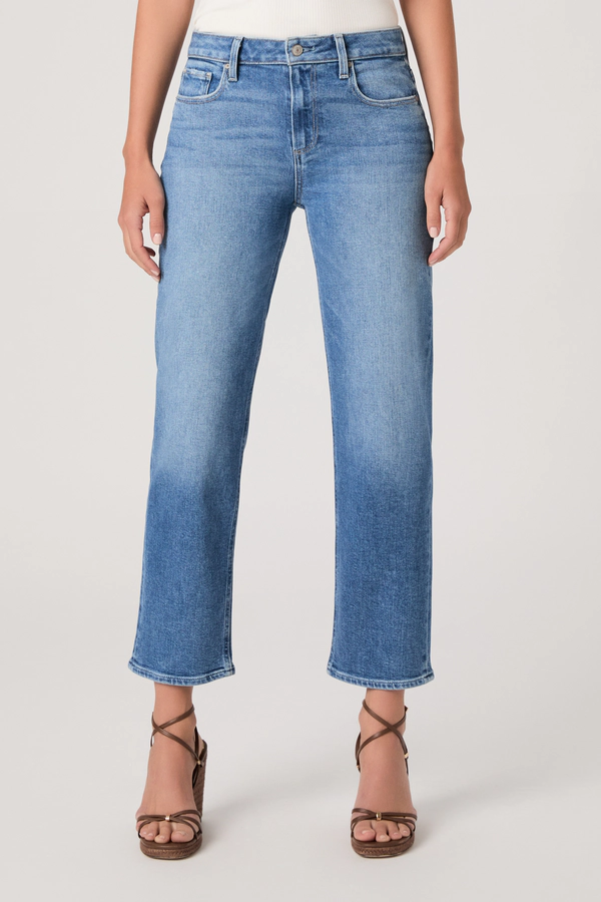 Person wearing blue jeans on a plain background