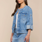 Woman wearing a denim jacket and skirt on a beige background