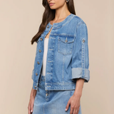 Woman wearing a denim jacket and skirt on a beige background