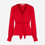 A bright red long-sleeve wrap blouse with a V-neckline and a self-tie waist belt, shown on a plain light gray background.