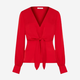 A bright red long-sleeve wrap blouse with a V-neckline and a self-tie waist belt, shown on a plain light gray background.