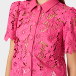 woman in pink lace top on white background 