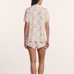 Woman wearing a floral pajama set on a plain background