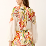 Woman wearing a colorful floral outfit on a white background