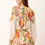 Woman wearing a colorful floral outfit on a white background