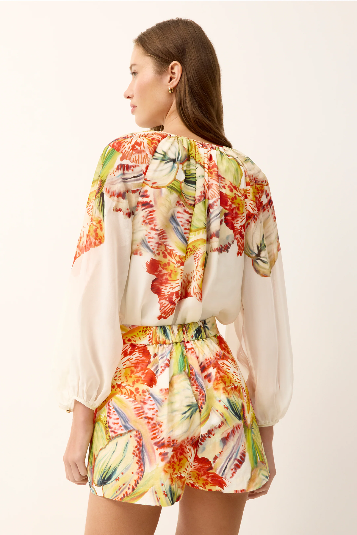 Woman wearing a colorful floral outfit on a white background