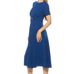 side view of woman in blue midi dress on white background 