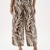 Zebra print pants worn by a person on a white background