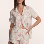 Woman wearing a floral pajama set on a plain background