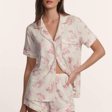Woman wearing a floral pajama set on a plain background