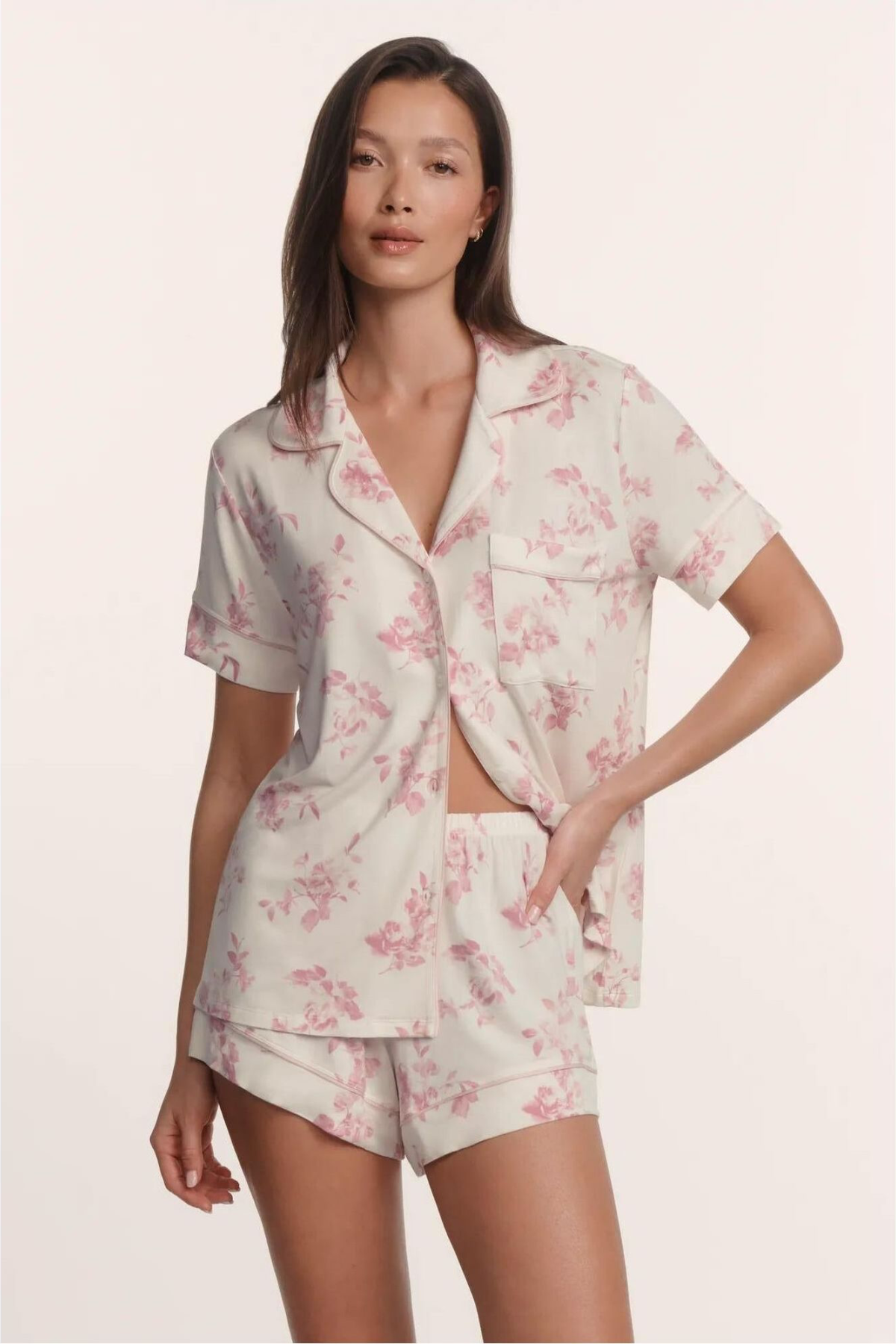 Woman wearing a floral pajama set on a plain background